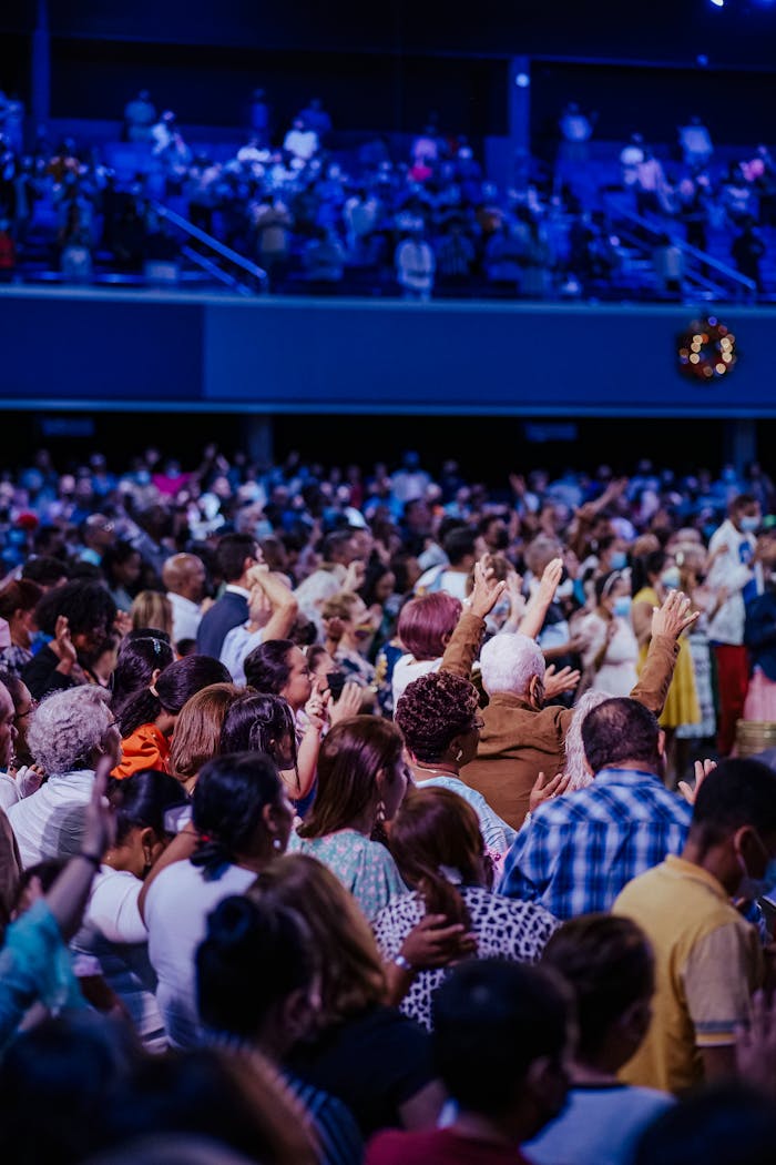 A large congregation engaged in worship inside a vibrant spiritual setting.
