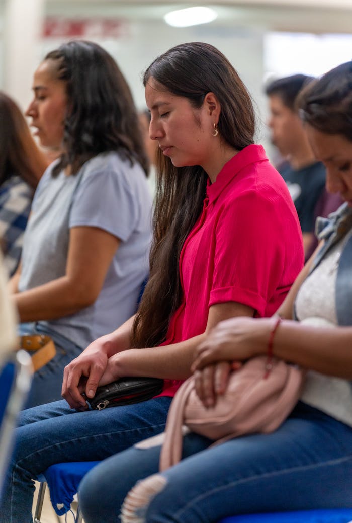 Women engage in silent prayer during a spiritual gathering in Mexico City, focusing on peace and faith.